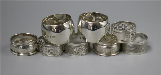 Three pairs of silver napkin rings and a plated pair of napkin rings.